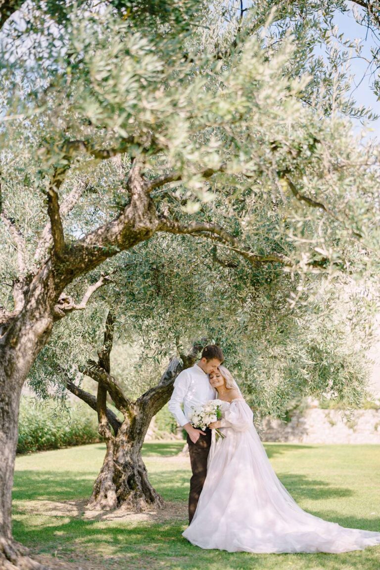 married couple posing under an olive tree