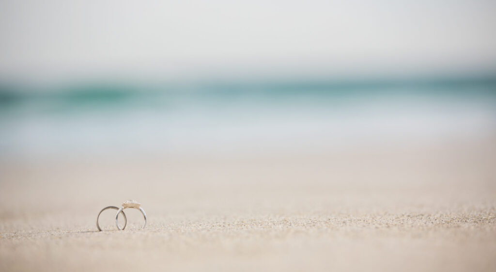 rings set in sand at destination wedding